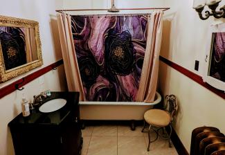 Toilet, vanity, chair, clawfoot tub and shower, shower curtains, light