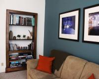 Couch, wall art, and shelf stocked with art books and activities