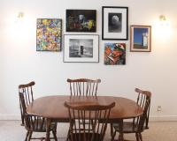 Dining area with large table and original artwork on the walls