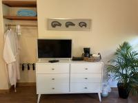 Dresser with TV and a closet nook with robes