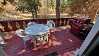 Deck with gas barbecue, tables and chairs.